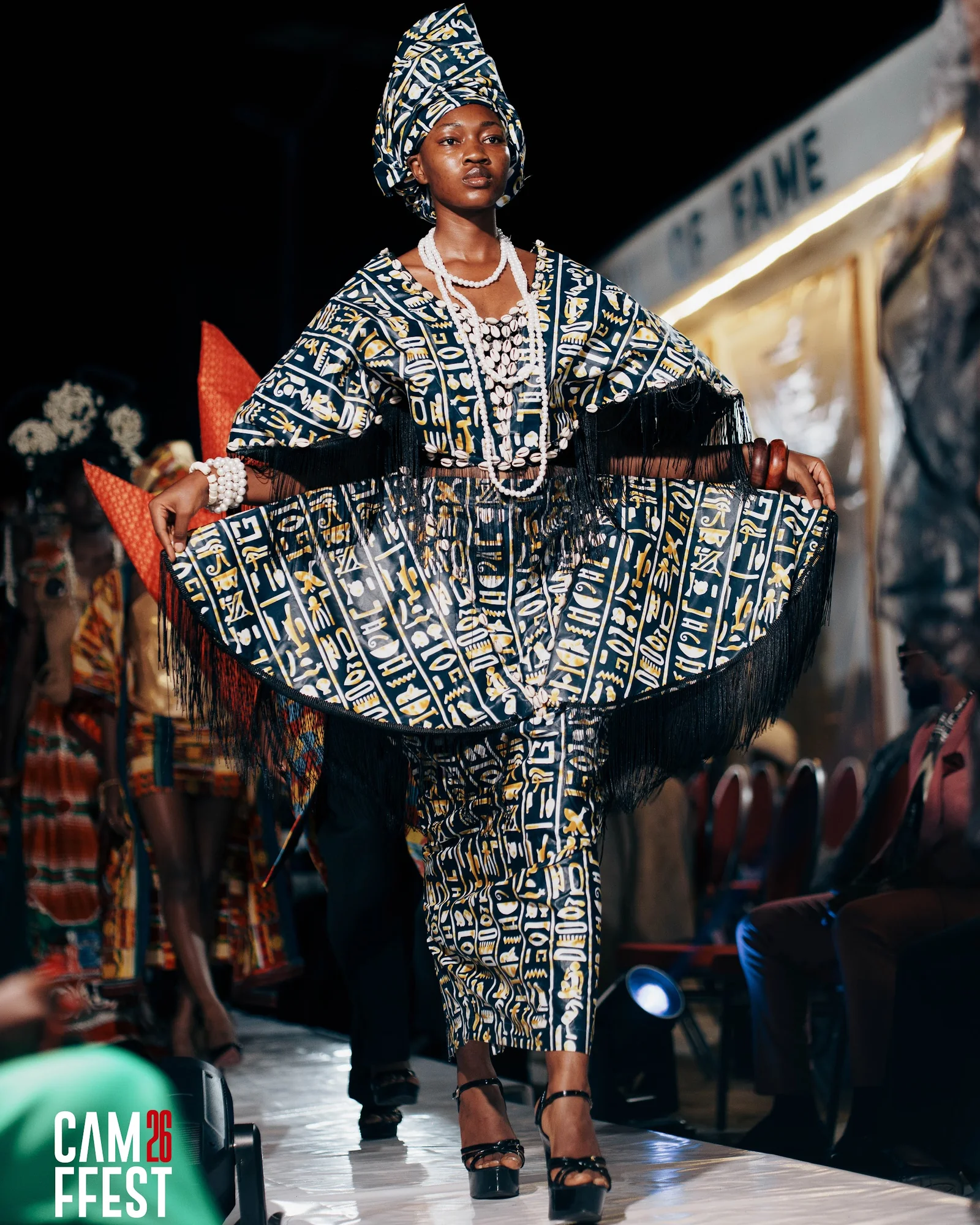 Model in a wide patterned dress on the CAMFFEST runway