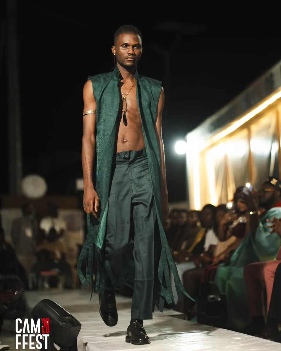 Model in a long green coat on the runway
