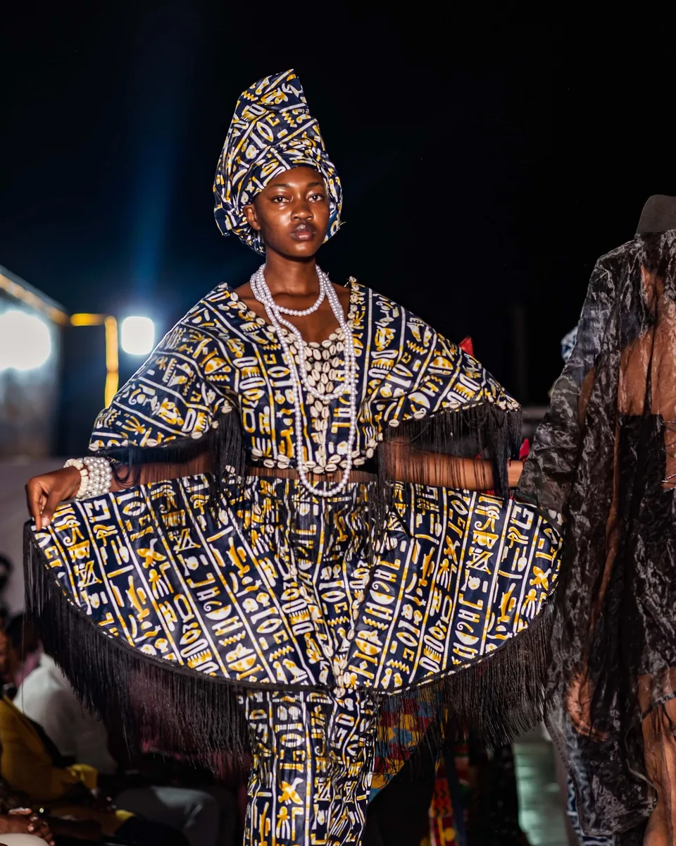 Model in a wide patterned dress and headwrap